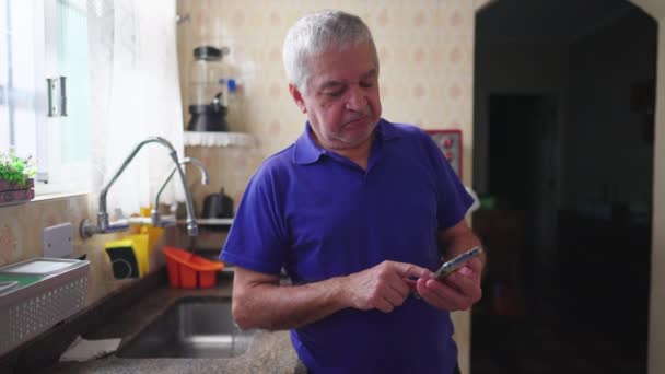 Joyful Senior Man Holding Cellphone Device Standing Kitchen Sink Home — Stock Video