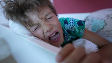 Yüzünü buruşturan çocuk korkmuş ve şok olmuş hissediyor.