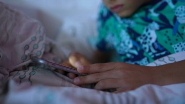 Küçük bir çocuk telefon cihazının üzerine yakın plan el yazısıyla kayıyor.