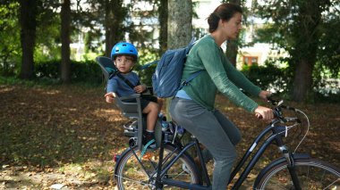 Bisiklet süren anne ve çocuk arka koltukta oturuyor.