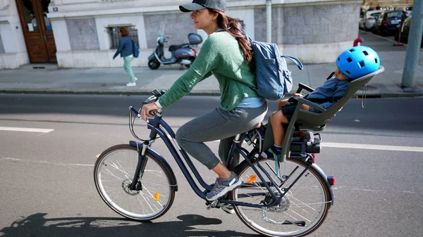 Cyclist mother riding bike with child