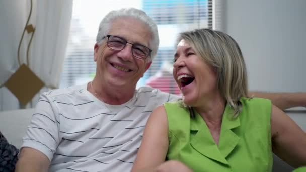 一对快乐的老夫妇笑着坐在家里的沙发上 真正快乐的老夫老妻笑了 — 图库视频影像