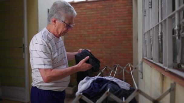 Πρεσβύτερος Βάζει Ρούχα Στεγνώσουν Στην Κρεμάστρα Στην Πίσω Αυλή Ανεξάρτητο — Αρχείο Βίντεο