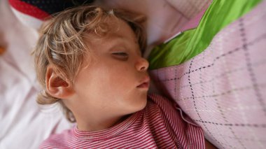 Huzurlu küçük çocuk uyuyan yüz kapalı çocuk kestiriyor.