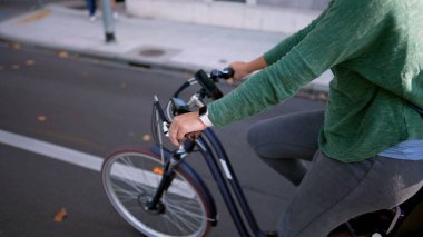 Şehir sokağında uyuyan çocukla bisiklet süren mutlu bir kadın.