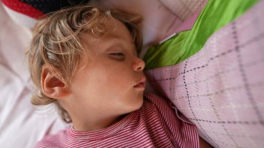 Huzurlu küçük çocuk uyuyan yüz kapalı çocuk kestiriyor.