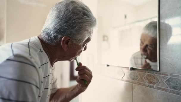 老年人每天早上都在镜子里刷牙 同时凝视着自己在浴室镜子里的倒影 口腔卫生 老年人开始新的一天 — 图库视频影像