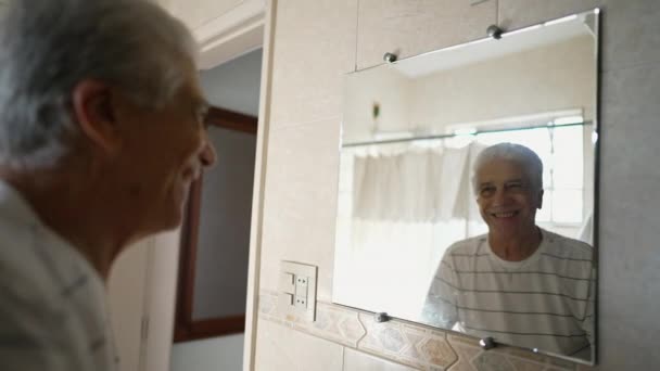 Ευτυχισμένος Ηλικιωμένος Άντρας Κοιτάζει Την Αντανάκλαση Του Μπάνιου Του Χαμογελώντας — Αρχείο Βίντεο