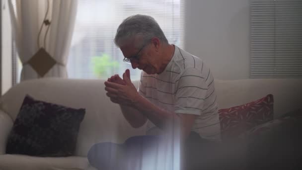 忧心忡忡的老年人一个人在家里苦苦挣扎着 心里充满了遗憾和焦虑 老年人坐在沙发上感到沮丧和全神贯注吗 — 图库视频影像