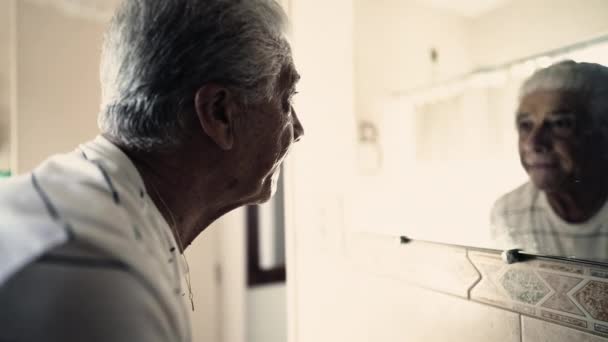 Besinnlicher Senior Blickt Auf Sein Spiegelbild Badezimmerspiegel — Stockvideo