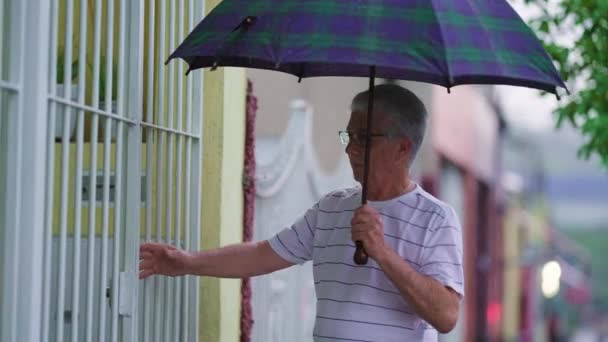 Volwassen Man Met Paraplu Komt Thuis Opent Poort Regen — Stockvideo