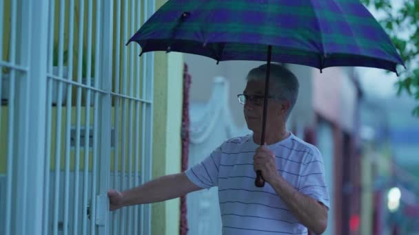 Yaşlı Adam Yağmurlu Bir Günde Elinde Şemsiyeyle Eve Geliyor Kapıyı — Stok video