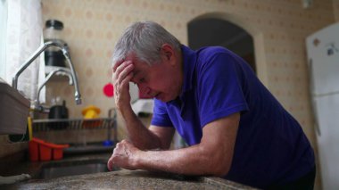 Bunalımlı son sınıf öğrencisi yalnızlık, endişe ve stres içinde. Evde yaşlı adam tarafından hissedildi. Mutfak lavabosuna yaslandı.