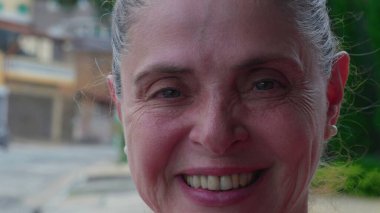 50 'li yaşlarda neşeli, olgun bir Brezilyalı kadın kameraya gülümsüyor.