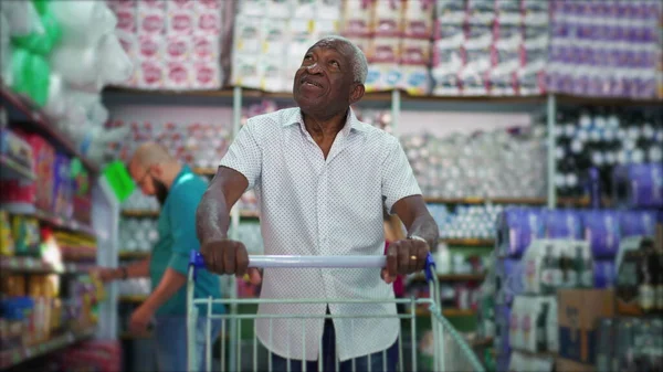 Joyful Senior African American Man Shopping in Grocery Store, Navigating Aisle with Cart, Candid Portrait of Elderly Customer at Local Business