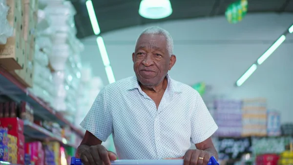 Senior African American Customer at Local Grocery Store, Pushing Cart and Browsing Products, Depicting Consumer Lifestyle Habits