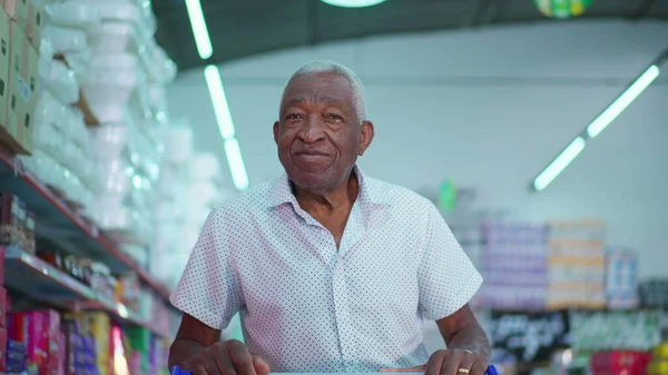 Senior African American Customer at Local Grocery Store, Pushing Cart and Browsing Products, Depicting Consumer Lifestyle Habits