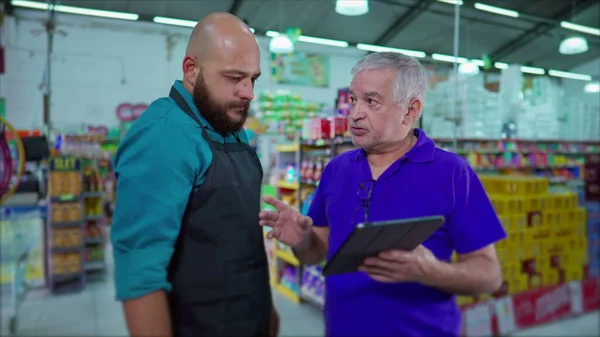 stock image Supermarket Manager Addressing Inventory Issue with Employee, Strict Boss Reprimanding Staff Holding Tablet at Grocery Store, Dispute at Workplace