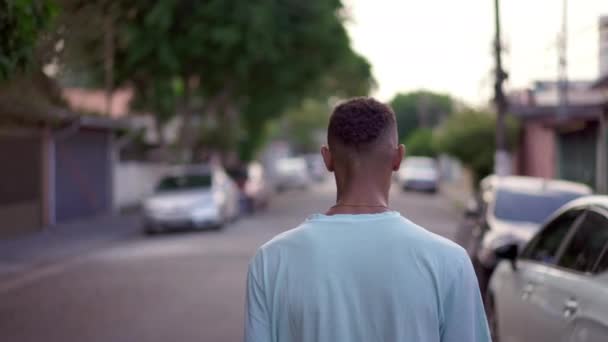 若い黒人の男が通りを歩いている アフリカ系アメリカ人が都市環境を歩いている 人生の旅のコンセプト — ストック動画