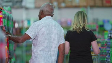 Consumer Behavior Depicted by Diverse Shoppers in Supermarket Aisle. Candid People shopping at grocery store clipart