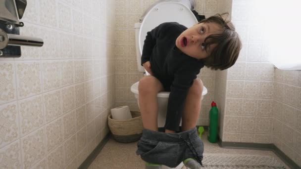 トイレの席に座っているかわいい男の子 彼の衛生上のニーズを満たしている子供 — ストック動画