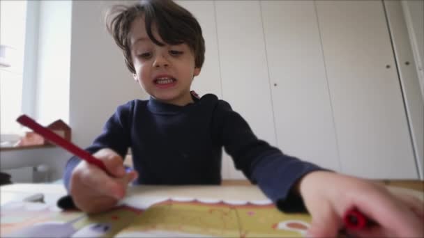家での芸術活動に従事する子供 リトルボーイは ペンを着色を使用して集中した表現で紙に描画 — ストック動画
