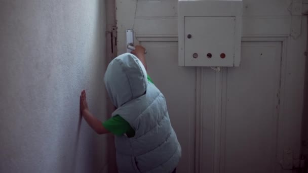 孩子们打开家里的前门 走在街上 一个小男孩的手拿着帽衫走到门把手 打开了住宅入口 — 图库视频影像