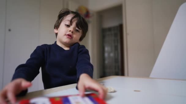 Один Маленький Хлопчик Збирає Книжку Сидячи Столом Спальні Концепція Виховання — стокове відео
