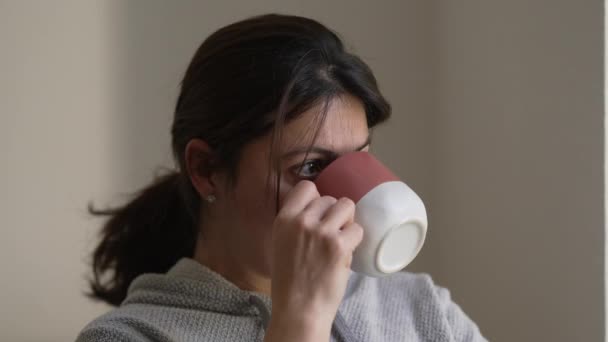 女人用沉思的表情喝着热饮 沉思的人在沉思中喝咖啡或茶 — 图库视频影像