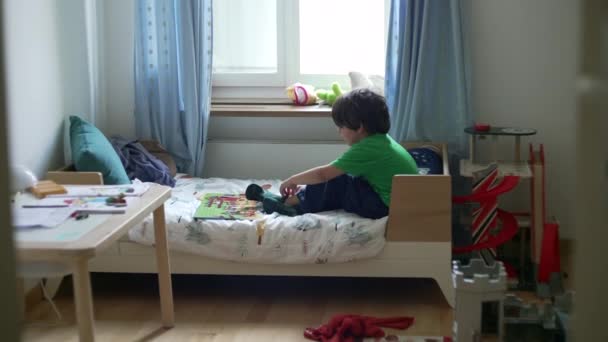 可爱的小男孩想把袜子放在卧室里的床上 孩子们在穿衣服时抱怨的不安情绪 — 图库视频影像