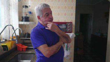 Derin zihinsel yansıması olan düşünceli bir son sınıf öğrencisi mutfakta durmuş, el pençe divan durup, kararını düşünüyor.