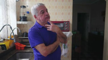 Derin zihinsel yansıması olan düşünceli bir son sınıf öğrencisi mutfakta durmuş, el pençe divan durup, kararını düşünüyor.