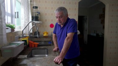 Stresli son sınıf öğrencisi mutfak lavabosuna yaslanıyor evde çaresizlik içinde debeleniyor, yaşlı insan yalnızlık, depresyon ve endişe içinde yalnız başına bunalıma giriyor.