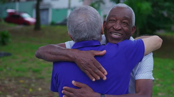 Two diverse Brazilian senior Friends Share Warm Embrace in Park. Old Age Friendship of elderly people Hugging, Displaying Camaraderie