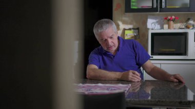 Ev mutfak masasında alkol içerken uyuyakalan sarhoş son sınıf öğrencisi. Alkolik yaşlı kişinin samimi tasviri