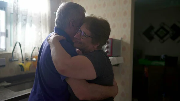 Romantic Scene of Elderly Couple Dancing by Kitchen Window, Senior Husband and Wife in Loving Embrace