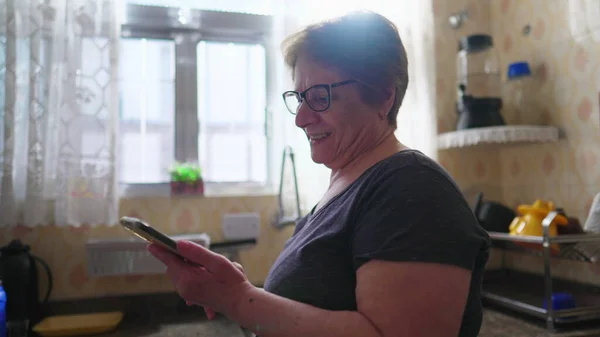 Радостная Пожилая Женщина Занятая Технологиями Читает Онлайн Контент Мобильном Телефоне — стоковое фото