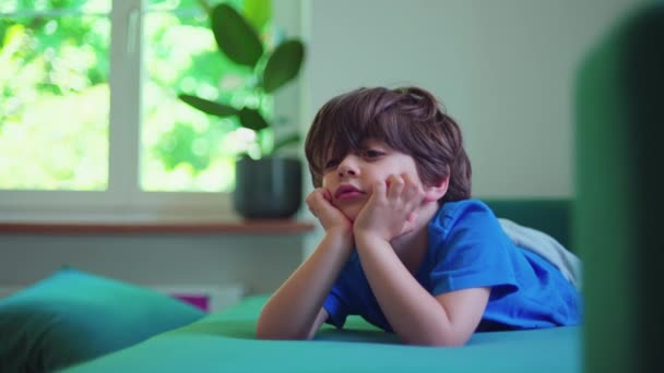 Small Boy Watching Cartoons Camera Hand Chin Absorbed Entertainment Content — Stock Video