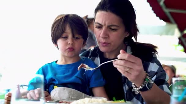 레스토랑에서 불안한 아이를 먹이는 어머니 음식을 먹이는 엄마의 무릎에 밖으로 — 비디오