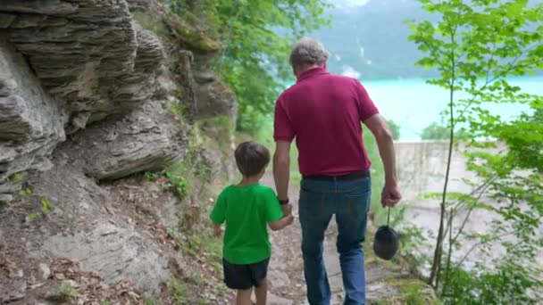 グランドソンと手を握る祖父の家族のハイキングアドベンチャーシーン トレイルパスで歩く おじいちゃんと子供の間の愛のつながり — ストック動画