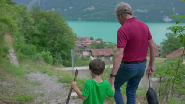 グランドソンと手を握る祖父の家族のハイキングアドベンチャー トレイルパスで歩く おじいちゃんと子供の間の愛のつながり — ストック動画