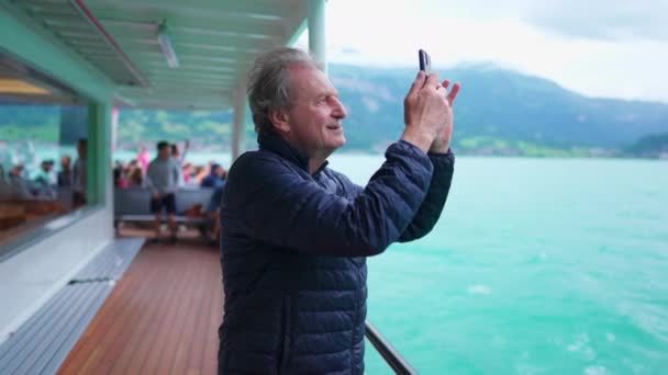 Старший Человек Путешествующий Лодке Достает Сотовый Телефон Сфотографировать Озеро Горы — стоковое видео