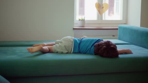 Скучающий Ребенок Лежит Диване Ничего Делает Беспокойный Маленький Мальчик Заземленный — стоковое видео