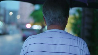 Yağmurlu bir günde Şemsiye ile Sokakta Yürüyen Yaşlı Adam 'ın Arka Görünümü