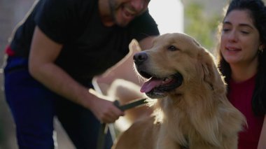 Golden Retriever Dog ve kadın parkın dışında gün ışığında. Çiftler güneşli bir günde hafta sonu aktivitelerinin keyfini çıkarıyorlar