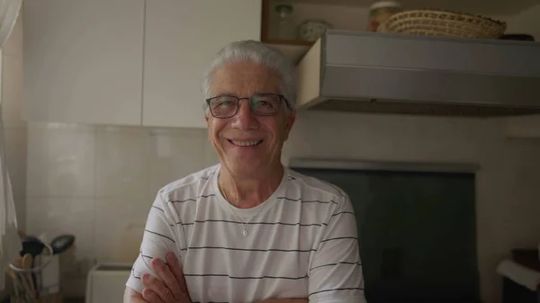 Χαρούμενος Πρεσβύτερος Άνδρας Χέρια Σταυρωμένα Στέκεται Στο Sunlit Κουζίνα Χαμογελώντας — Φωτογραφία Αρχείου