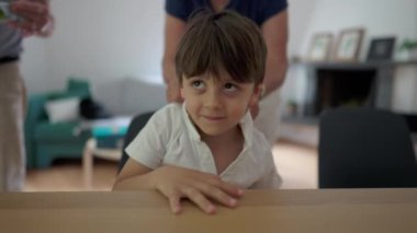 Büyükannem, torununun polo yakasını içeride düzeltiyor. Sevecen büyükanne, çocuğun kıyafetlerini dengeliyor.