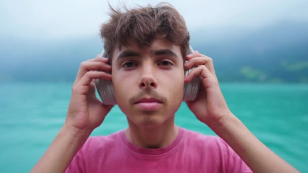 Πορτρέτο Του Νεαρού Αγοριού Βάζοντας Ακουστικά Ακούγοντας Ήχο Θέα Λίμνη — Αρχείο Βίντεο