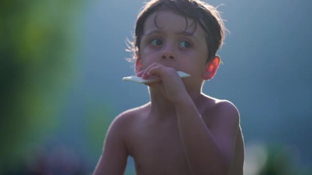 Θλιβερό Παιδί Τρώει Μπισκότο Ενώ Στεγνώνει Στον Ήλιο Μετά Παιχνίδι — Αρχείο Βίντεο