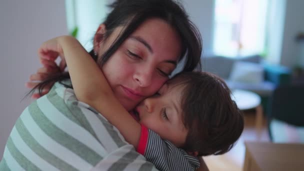 母は小さな息子を抱きしめ 愛情を込めて自宅で抱きしめています 愛情あふれる母親の周りの腕を持つ子供 本物の愛を頬にする頬 — ストック動画